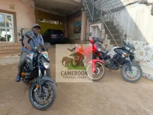 Motard en plein road trip sur une piste de terre rouge au Cameroun